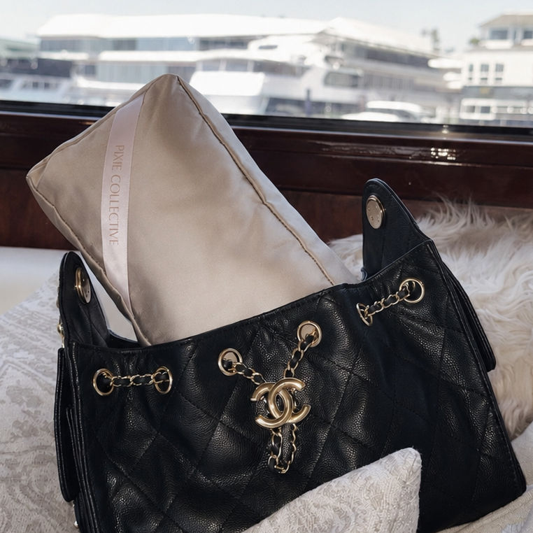 Cream Pixie Collective purse pillow inside a black quilted Chanel tote bag, illustrating essential care tips for new designer handbag owners